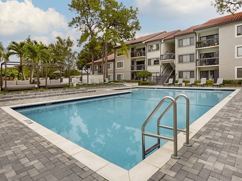 a swimming pool with an apartment building in the background